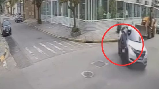 Câmeras de segurança registraram o momento em que criminosos se aproximaram do motociclista ferido para roubar seus objetos - Imagem: Reprodução