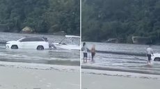 Carro ficou parcialmente submerso após atolar na faixa de areia da Praia da Enseada, em Bertioga, nesta sexta-feira (11). O veículo foi retirado pelo proprietário e ninguém ficou ferido - Imagem: Reprodução/Redes Sociais