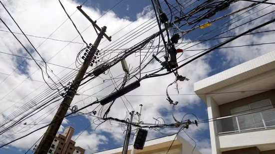 A lei abrange todos os serviços públicos que utilizam fiação aérea, incluindo energia elétrica e telecomunicações, com prazos de adaptação - Imagem: Reprodução