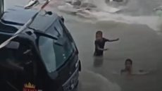 Crianças brincando em água suja enfrentam risco de atropelamento por caminhão em Guarujá durante chuvas intensas - Imagem: Reprodução/ Guarujá Mil Grau