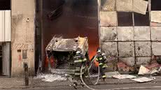 Um incêndio de grandes proporções em Guarujá destruiu caminhões em uma oficina, mas a rápida ação dos bombeiros evitou danos maiores - Imagem: Reprodução