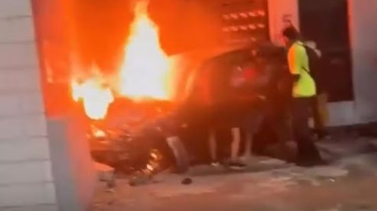 Carro pegou fogo após atropelar um ciclista e bater contra o muro de um estabelecimento, na Avenida Ministro Marcos Freire, em Praia Grande. Motorista de 32 anos foi preso após teste do bafômetro apontar presença de álcool - Imagem: Reprodução