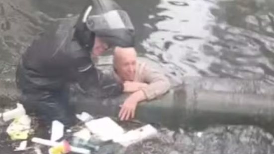 Um grupo de moradores se arrisca para salvar um idoso que caiu no Canal 3 durante forte chuva em Santos nesta quarta-feira - Foto: Reprodução/ Redes Sociais