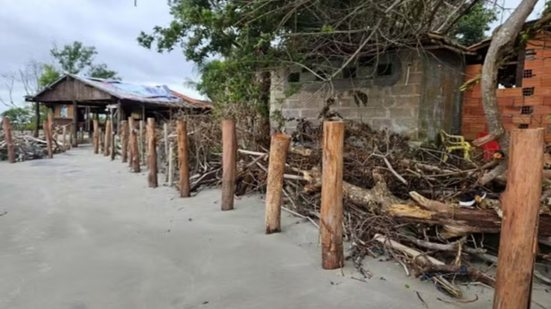 Estruturas improvisadas de contenção foram instaladas na faixa costeira da Ilha do Cardoso para tentar reduzir o avanço da erosão próximo às moradias de comunidades tradicionais - Imagem: Reprodução/MP-SP