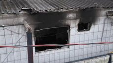 Equipes do Corpo de Bombeiros atenderam a ocorrência no bairro Paecará, em Guarujá, após um incêndio atingir uma residência na noite de domingo (2). Uma criança morreu e outra ficou ferida - Imagem: Abner Reis/TV Tribuna