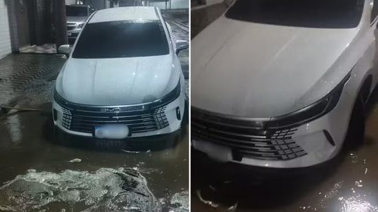 Carro de motorista de aplicativo ficou preso em um buraco encoberto pela água da chuva na Avenida Integração, em Praia Grande, na madrugada desta terça-feira (22). O veículo foi retirado com auxílio de um guincho - Imagem: Alexandre de Jesus Rodrigues