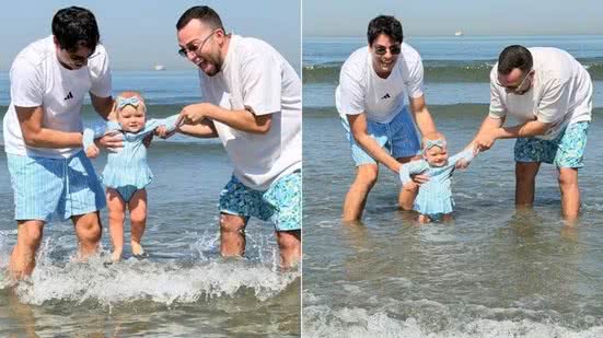 Lucas Rangel e Lucas Bley levaram a filha Mia, de 10 meses, para conhecer o mar pela primeira vez durante visita a Santos, cidade natal de Bley - Imagem: Reprodução/Redes sociais